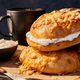 Panera Asiago bagel on table with cup of coffee